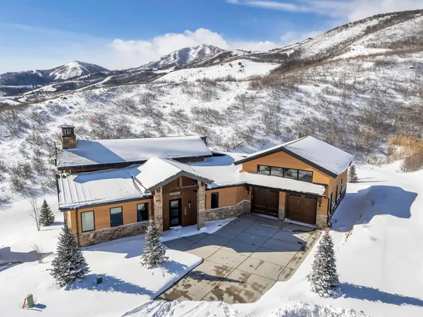 Crackstone, a Mayflower home in SkyRidge, snow-covered with wood and stone siding